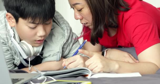 Asiático Mãe Ajuda Seu Jovem Filho Enquanto Menino Está Fazendo — Vídeo de Stock