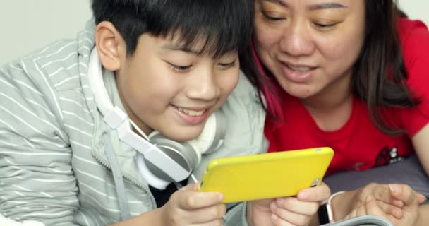 Szczęśliwa Młoda Matka Syn Oglądania Komórki Potem Patrząc Przez Telefon — Wideo stockowe