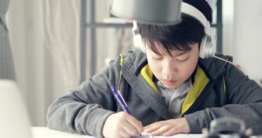 Genç genç öğrenci aşağı taşı dinle müzik ve evde ödev yapmak için