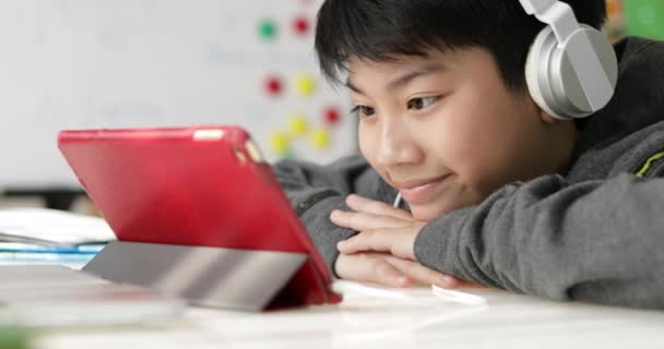 Dolly Shoot Young Asian Boy Playing Tablet Computer Headphone Home — Stock Video