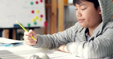 Öfkeli Asya çocuk ile ödev hakkında endişeli hissediyorum, merak ve yorgun. Soldan sağa dolly taşıma.