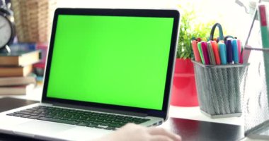 Omuz görünümünü üzerinde? genç çocuk dizüstü bilgisayarda izliyor. Yeşil ekran teknolojisi kullanılıyor. Chroma anahtar laptop. Dolly taşıma sağdan sola.