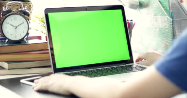 パソコンで見ている少年の肩越しにドリー 使用されているテクノロジの緑色の画面です クロマ キーのノート パソコン — ストック動画