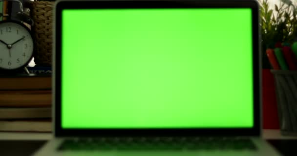 Dolly sur ordinateur portable avec écran vert. Bureau sombre. Parfait pour mettre votre propre image ou vidéo.Écran vert de la technologie utilisée. Chroma Key ordinateur portable 