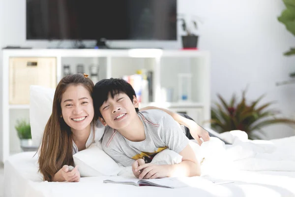 アジアの妹と弟リラックスやそこに自宅のベッドでのプレー — ストック写真
