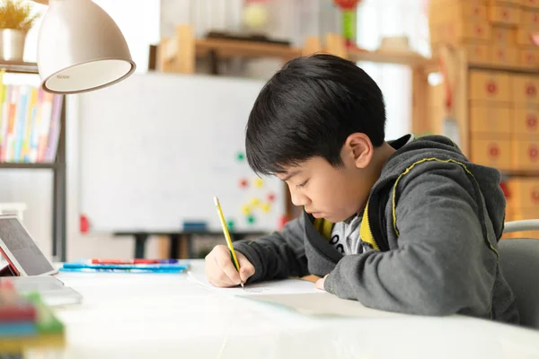 家で宿題をしている若いアジア 代学生 — ストック写真