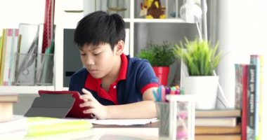 Asya ergenlik olan tablet bilgisayar ile ciddi bir yüz ödevlerini yapıyor.