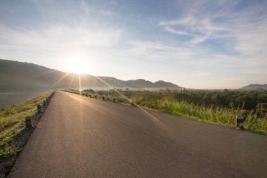 Asfalt yol rezervuar açıkça mavi gökyüzü ve falre içinde belgili tanımlık geçmiş Huaiprue depo, Nakhon Nayok Tayland ile Dağları ile.