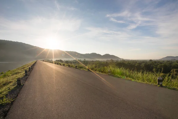 Asfalt yol rezervuar açıkça mavi gökyüzü ve falre içinde belgili tanımlık geçmiş Huaiprue depo, Nakhon Nayok Tayland ile Dağları ile.