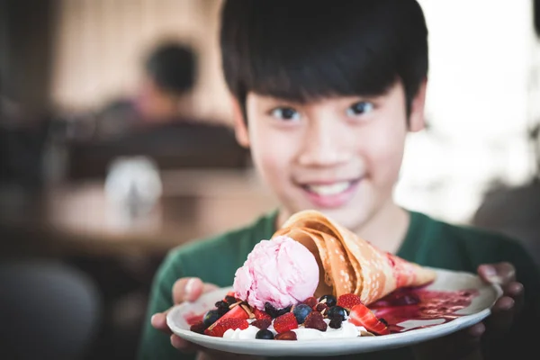兴奋的亚洲孩子带着微笑的脸显示甜点 把华夫饼放在盘子上 — 图库照片