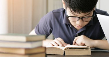 Sevimli Asya teen çocuk ödevini evde yapıyor.