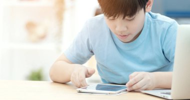 Asya sevimli çocuk gülümsemek yüz evde tablet bilgisayarda izliyorum.