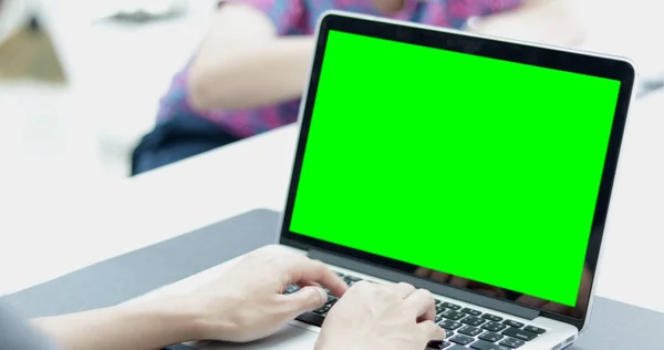 在一个亚洲男人的肩膀上拍摄在一台膝上型计算机上 在工作组前面设置了一个关键的绿色屏幕 — 图库照片
