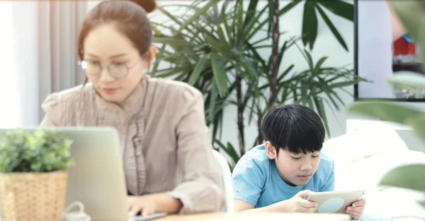 Businesswoman Working Laptop Her Workstation Home Boy Playing Tablet Computer — Stock Photo, Image