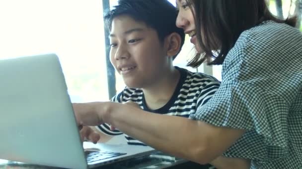 スローモーション 幸せアジア家族母と息子笑顔と一緒にパソコンで見て — ストック動画
