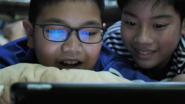 Yavaş hareket 4 k mutlu Asya ergenlik gülümsemek yüz ile tablet bilgisayarda izliyorum.