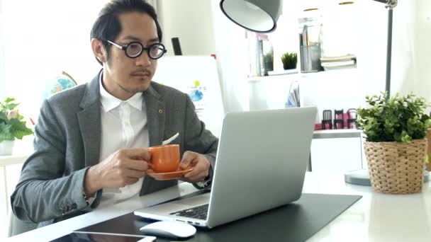 在办公室的笔记本电脑工作的生意人 慢动作亚洲商人穿着眼镜在办公室 — 图库视频影像