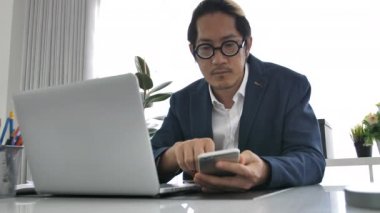 Dizüstü bilgisayar ve cep telefonu kullanarak Office iş adamı, 4 k yavaş hareket Office adam konuşmak ve yazmak üstünde hareket eden telefon .