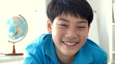 Kameraya gülümsemek yüz, 4 k ile mutlu Asyalı çocuk evde yavaş hareket arıyorsunuz Asya varoluş portresi.