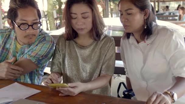 Красивая Азиатская Женщина Показывает Интересные Вещи Своем Смартфоне Своим Друзьям — стоковое видео