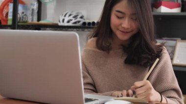 Asyalı kız dizüstü bilgisayarda yazarak ağır çekim. Şirin Tayland kadın model dizüstü gülümsemek yüz ile kullanma .