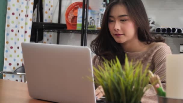 アジアの女の子はラップトップ コンピューターに入力のスローモーション 笑顔でラップトップを使用してかわいいタイの女性モデル — ストック動画