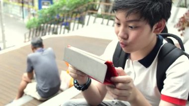 Asyalı çocuk gülümsemek yüz, ağır çekim tablete izliyor ve rahatlatıcı Tayland çocuk tablet bilgisayarda oynama.