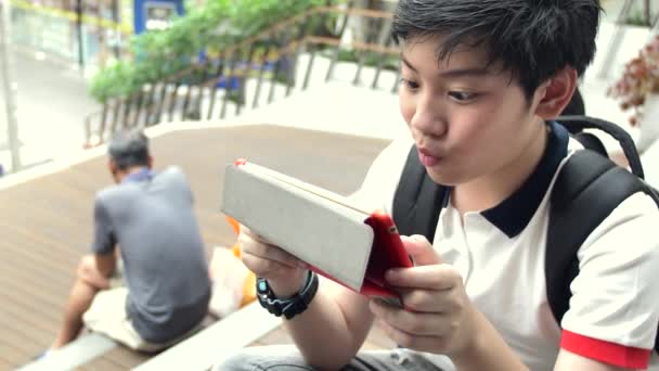 亚洲男孩在平板电脑上玩面带微笑的脸 泰国男孩在平板电脑上观看和放松的慢动作 — 图库视频影像