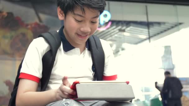 Asiatischer Junge Spielt Auf Tablet Computer Mit Lächeln Gesicht Zeitlupe — Stockvideo
