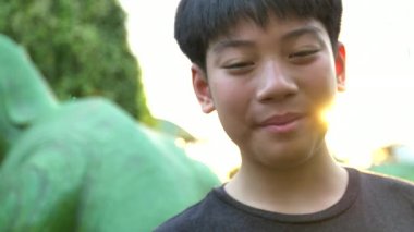 Asyalı çocuk kameraya gülümsemek yüz ile seyir portresi kaydedildi yavaş çekimde el 4 k 60 fps.