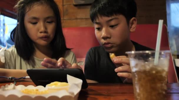 Šťastné Asijské Dítě Sledování Mobilním Telefonu Chutnají Bramborové Nati Zpomalené — Stock video