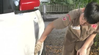 Asyalı erkek tek tip araç evde, Tayland izci Ailen evde yardımcı yıkama izci.