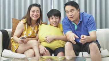 Asya Aile Baba Anne ve oğlu kanepede, ağır çekim, Looking kamera gülümseme ile yüz.