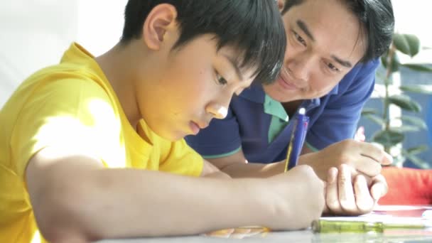 Mouvement Lent Père Asiatique Avec Son Fils Faisant Ses Devoirs — Video