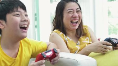 Asya Anne ve oğlu video oynarken evde together.4k ağır çekim mutlu aile gülümseme yüzünü ile oynarken oyun.