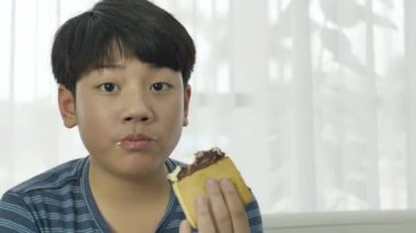 Ağır çekim küçük Asya çocuk evde dondurma yemek keyfini çıkarın. 4k