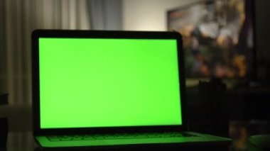 Yeşil ekran ile dizüstü bilgisayar. Karanlık ev ofis. Kendi resim veya video koymak mükemmel görüntüsünü Dolly. 