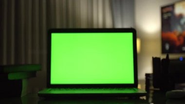 Yeşil ekran ile dizüstü bilgisayar. Karanlık ev ofis. Kendi resim veya video koymak mükemmel görüntüsünü Dolly. 