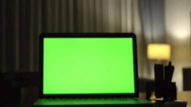 Yeşil ekran ile dizüstü bilgisayar. Karanlık ev ofis. Kendi resim veya video koymak mükemmel görüntüsünü Dolly. 