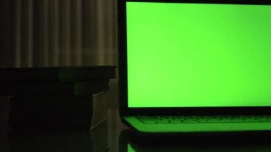 Yeşil ekran ile dizüstü bilgisayar. Karanlık ev ofis. Kendi resim veya video koymak mükemmel görüntüsünü Dolly. 