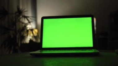 Yeşil ekran ile dizüstü bilgisayar. Karanlık ev ofis. Kendi resim veya video koymak mükemmel görüntüsünü Dolly. 