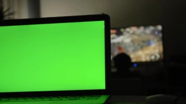 Yeşil ekran ile dizüstü bilgisayar. Karanlık ev ofis. Kendi resim veya video koymak mükemmel görüntüsünü Dolly. 
