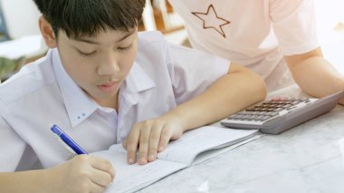 Asya Anne oğlunu beyaz masada ödev yardım.