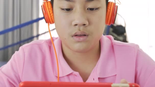 Happy Asian Boy Playing Tablet Computer Orange Headphone Teenage Boy — Stock Video