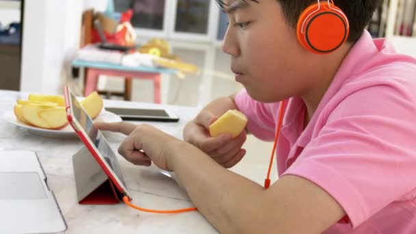 Feliz Asiático Chico Jugando Tableta Ordenador Con Naranja Auriculares Adolescente — Vídeos de Stock