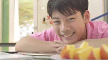 Asya sevimli çocuk portresi evde gülümseme yüzü ile kameraya bakıyor.