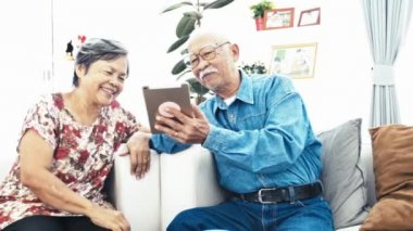 Asya kıdemli çift e-alışveriş ile dijital tablet, kıdemli çift ile online alışveriş Dolly atış yüz gülümse. 4 k yavaş hareket.