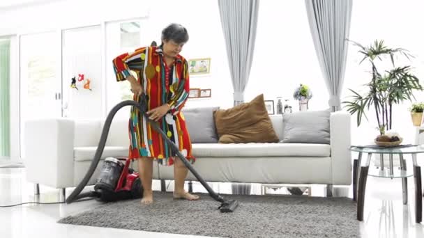 Wanita Senior Asia Yang Menyedot Debu Rumah Menari Dan Bernyanyi — Stok Video
