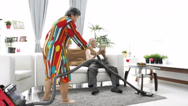 快乐的亚洲老人玩平板电脑和高级女子在家里吸尘地板 慢动作 — 图库视频影像
