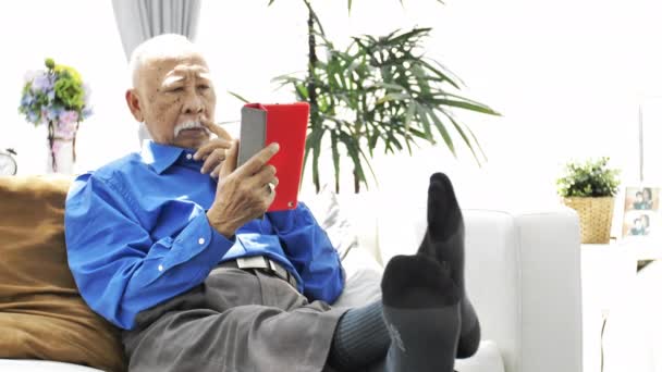 Aziatische Senior Man Met Witte Snor Met Behulp Van Tablet — Stockvideo